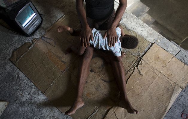 Loavia Bienaimé, de 30 años, consuela a su hija menor, Martina Haitianos convierten ruinas del terremoto en hogares