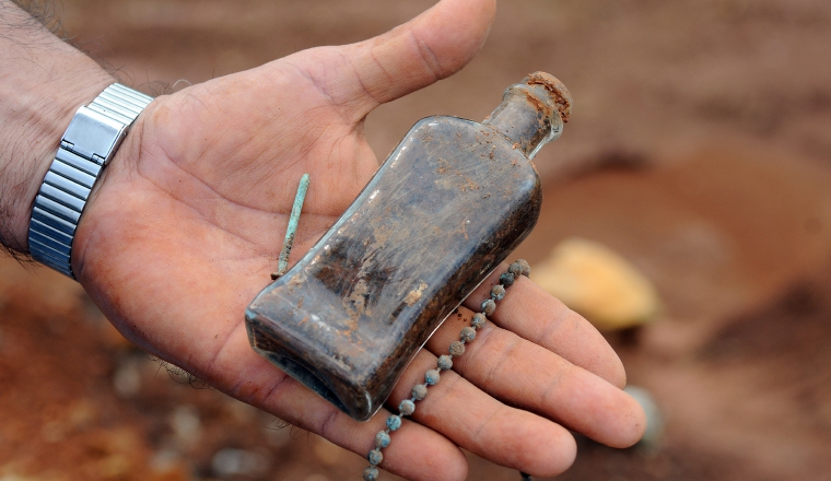 Botella de vidrio y cadena halladas en trabajos de excavación. Botella de vidrio y cadena halladas en trabajos de excavación.