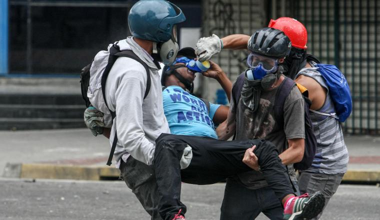 Manifestantes cargan a un compañero herido. Manifestantes cargan a un compañero herido. /Foto efe