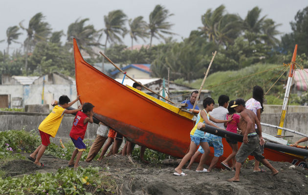 Pescadores y niños aseguran un bote antes de la llegada del tifón Mangkhut. Foto: EFE Pescadores y niños aseguran un bote antes de la llegada del tifón Mangkhut. Foto: EFE