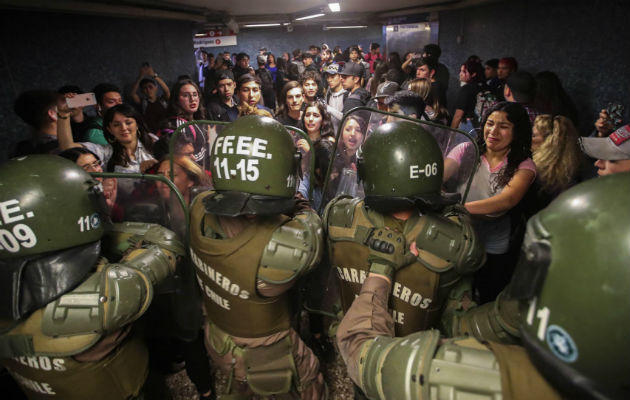 Disturbios por precio del Metro se extienden por Santiago y la ciudad colapsa Carabineros de la Policía chilena cierran el acceso a la estación del metro Los Héroes en Santiago. Foto: EFE.
