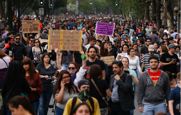 Un millón de personas marchan en Chile contra Piñera y la desigualdad social Encapuchados montan barricadas frente a la policía tras manifestarse en el centro de Santiago. Foto: EFE.