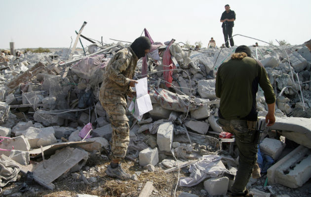 Perro del Ejército de EE.UU., héroe de la operación militar contra líder del EI Personas sobre el edificio destruido en Barisha, Siria, donde murió el líder del Estado Islámico. Foto: EFE.