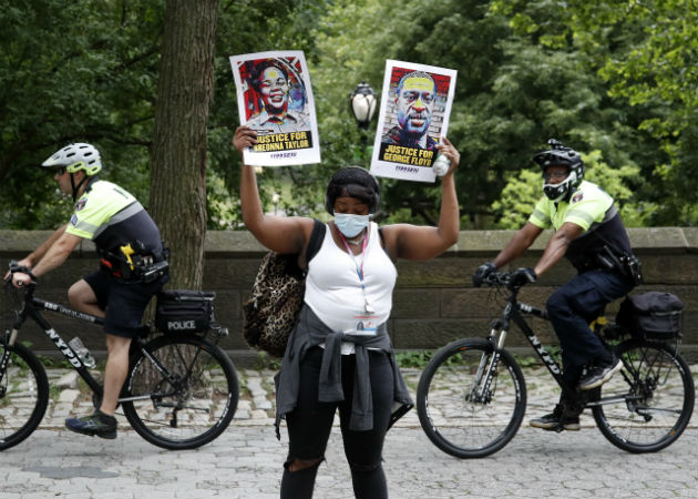 Nueva York investiga un nuevo caso de brutalidad policial contra un menor negro Una manifestante porta retratos de afroamericanos víctimas del racismo. Fotos: EFE.
