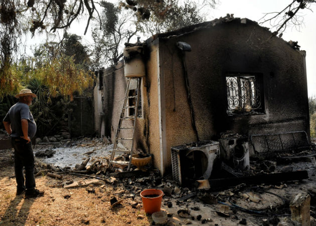 Miles de evacuados por el mayor incendio forestal de la época en el Peloponeso griego Un hombre observa su vivienda arrasada por el incendio forestal. Fotos: EFE.