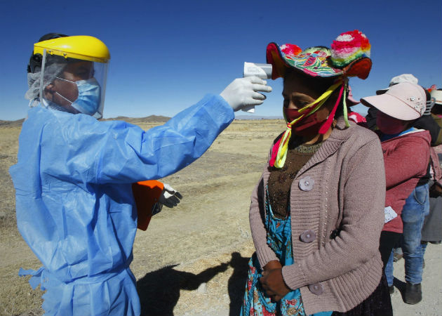 Perú volverá a confinamiento social los domingos por rebrotes de COVID-19 Un hombre toma la temperatura a mujeres Quechuas en la localidad de Coata, a unos cuarenta minutos de la ciudad de Puno (Perú). Fotos:EFE.