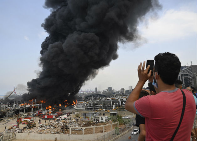 Un helicóptero de la armada lanza agua al fuego en el puerto de Beirut (Líbano). Fotos:EFE.