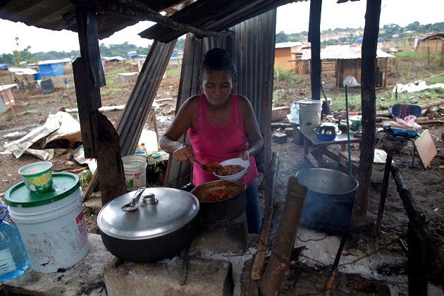 Yeisi Rodríguez, de 47 años, cocina en una casa improvisada en el terreno "Victoriano Lorenzo". Foto: EFE Yeisi Rodríguez, de 47 años, cocina en una casa improvisada en el terreno "Victoriano Lorenzo". Foto: EFE