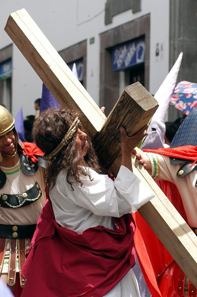Un penitente ecuatoriano, representando a Cristo carga una pesada cruz, origen de todas las expresiones sobre llevar una cruz en la vida