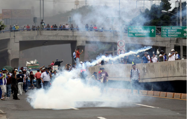 Manifestantes y policías se enfrentan en segundo día de protestas en Honduras Personas se enfrentan a efectivos de la Policía hondureña en el segundo día de paro nacional, en Tegucigalpa. EFE