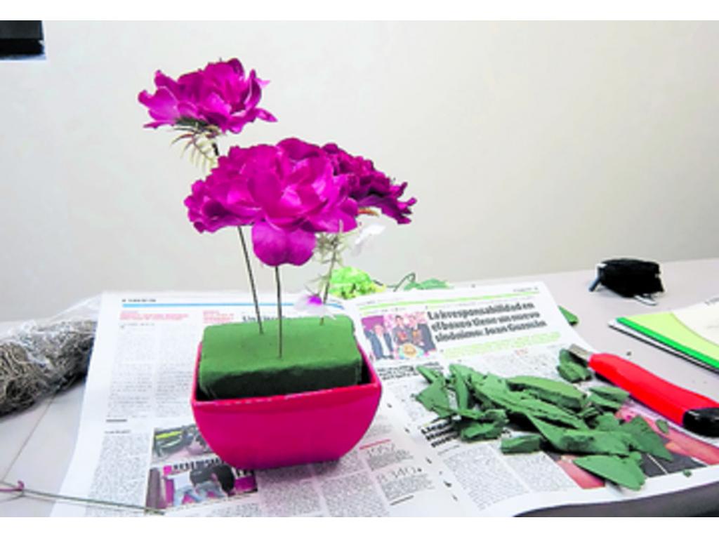 Después de cortar el oasis y moldearlo con el exacto para que encaje en el recipiente, se van distribuyendo las flores y las hojas en forma equilibrada.()