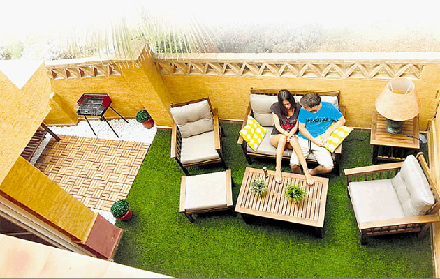 Decoración de terraza pequeña con grama sintética y muebles ligeros
