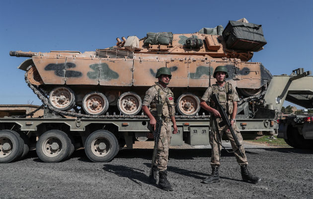 Turquía asegura haber tomado la primera ciudad en la franja kurda de Siria Jóvenes con la bandera turca al paso de blindados militares turcos en el noreste de Siria. Foto: EFE.