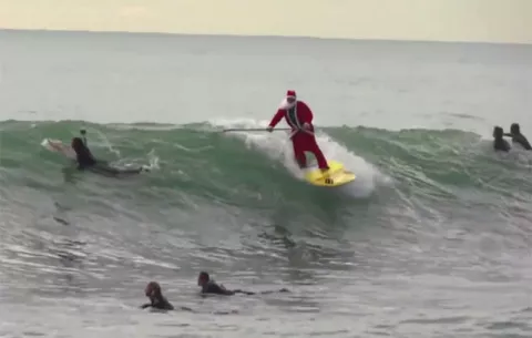 Santa Claus surfea en sus vacaciones antes de la navidad