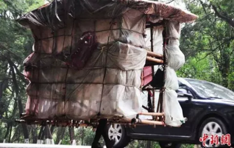 Un "hombre caracol" viaja por China cargando a cuestas su propia casa