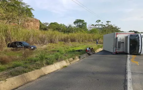 Camión de reparto avícola impacta auto enviándolo hacia un herbazal