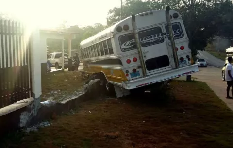 Conductor de bus se estrella contra cerca de una casa