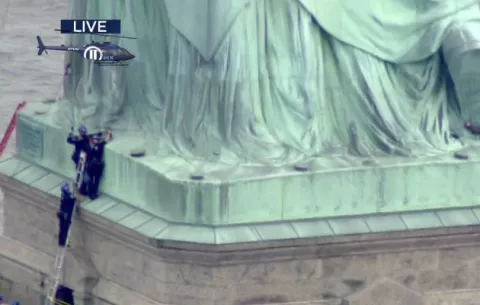 Mujer escala la Estatua de la Libertad para protestar contra política migratoria