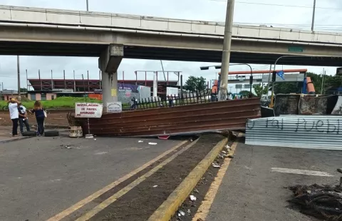  Barricada con hojas de zinc y materiales de hierro mantienen bajo el puente en Santiago 