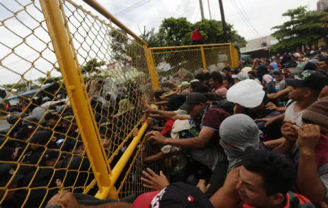 Migrantes rompen valla entre Guatemala y México y se enfrentan con la Policía