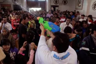 Sacerdote en México utiliza una pistola de agua para esparcir el agua bendita