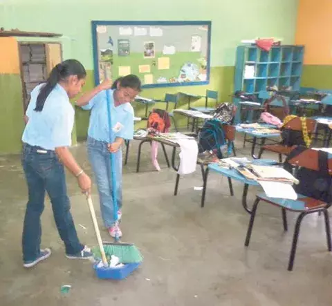 Reemplazan libros por escobas y cepillos para  limpiar  salones y baños 