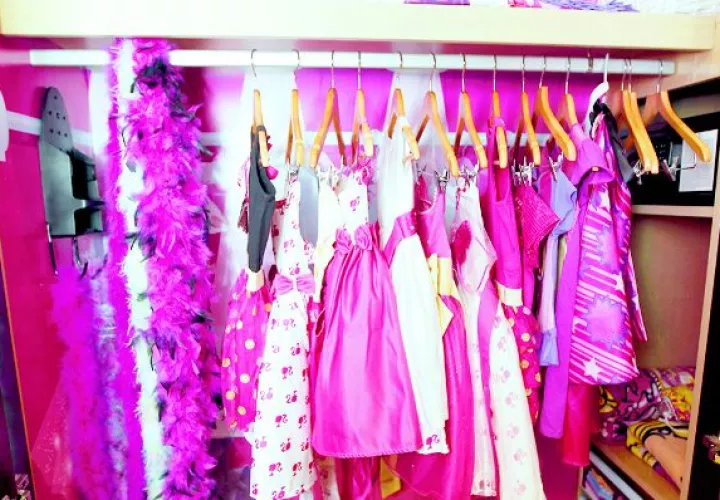 Hay vestidos, zapatos y accesorios en la habitación. 
