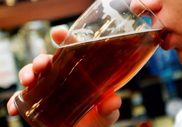 Una mujer bebe una cerveza. Foto: EFE