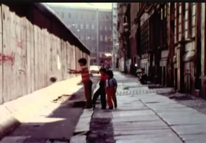 Niños jugando al lado del muro de Berlín, foto captura del documental Hasta la Frontera
