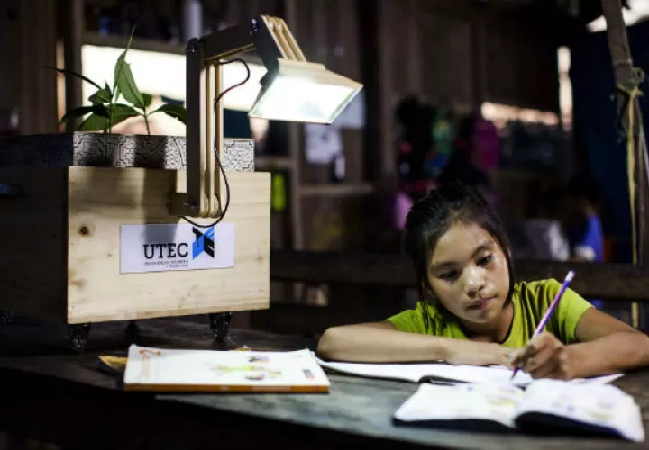 Una niña realiza sus actividades escolares a la luz de una "plantalámpara". Foto/ EFE