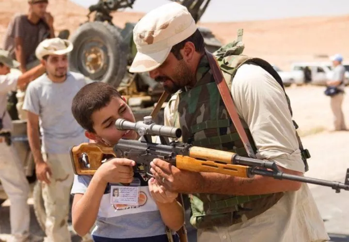 Un francotirador libio muestra un fusil ruso Dragunov a un chico durante el asedio rebelde a Bani Walid. Foto:AFP