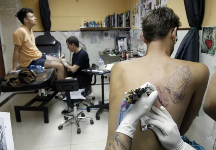Jóvenes se tatúan en “La Marca”. Foto/ EFE
