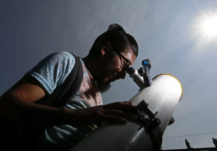 Un hombre observa con un telescopio el tránsito del planeta Mercurio frente al Sol, en la ciudad de Puebla (México). Foto/EFE 