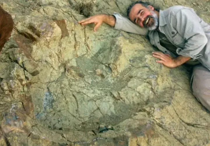 Paleontólogo argentino Sebastián Apesteguía, en donde posa junto a la huella más grande. FOTO/EFE