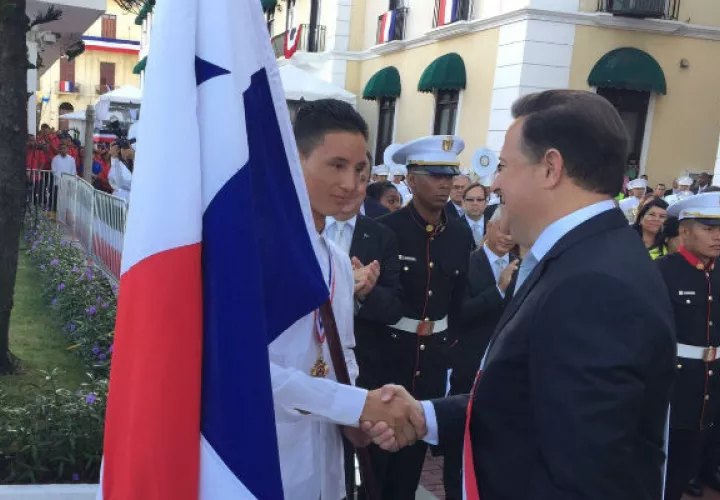 Al momento de recibir el pabellón de manos del presidente Varela.