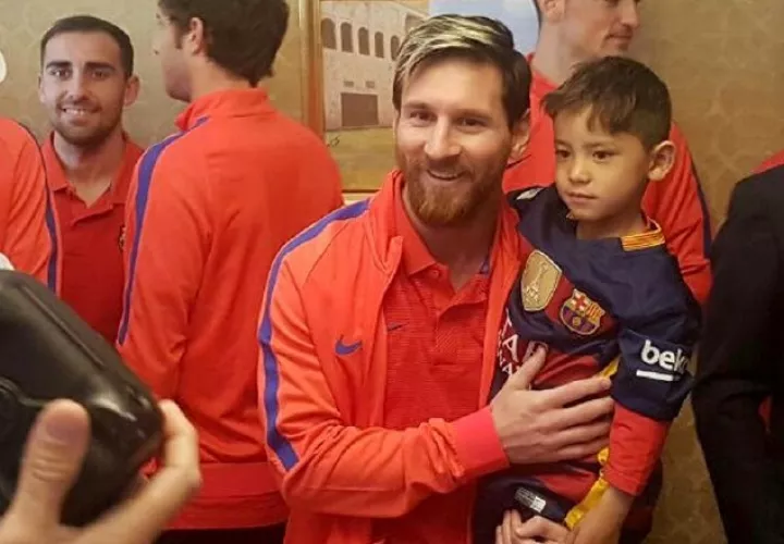 El niño afgano Murtaza Ahmady (dcha.) siendo cargado por su ídolo, el astro argentino Lionel Messi. /Foto EFE