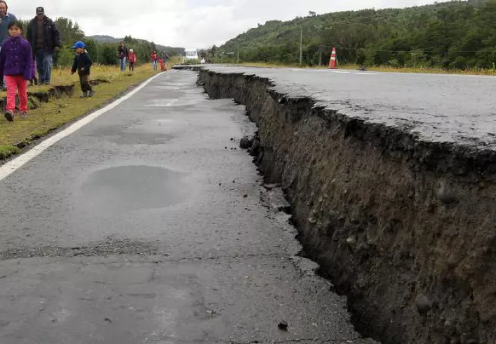 Personas caminan junto a una carretera destruida por el sismo. /Foto EFE