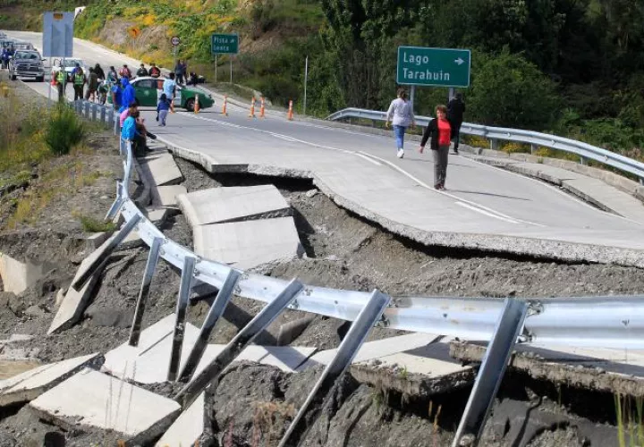 Varias personas transitan por una carretera destruida por el sismo del domingo, en Tarahuin, en la isla de Chiloé, al sur de Santiago. /Foto EFE