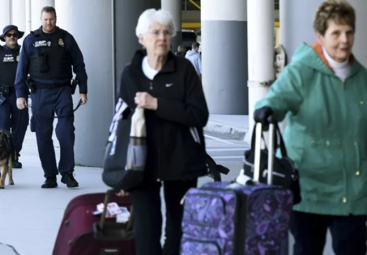 Pasajeros tratan de recuperar sus maletas. /Foto AP