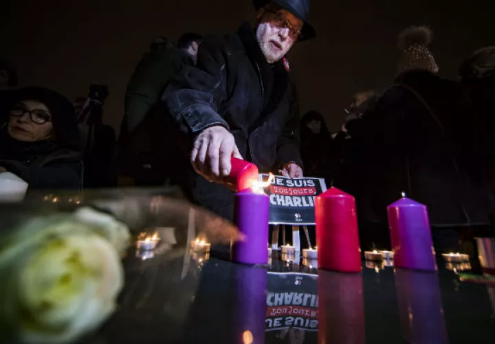 Un grupo de personas ponen velas en la Plaza parisina de la República. FOTO/AP