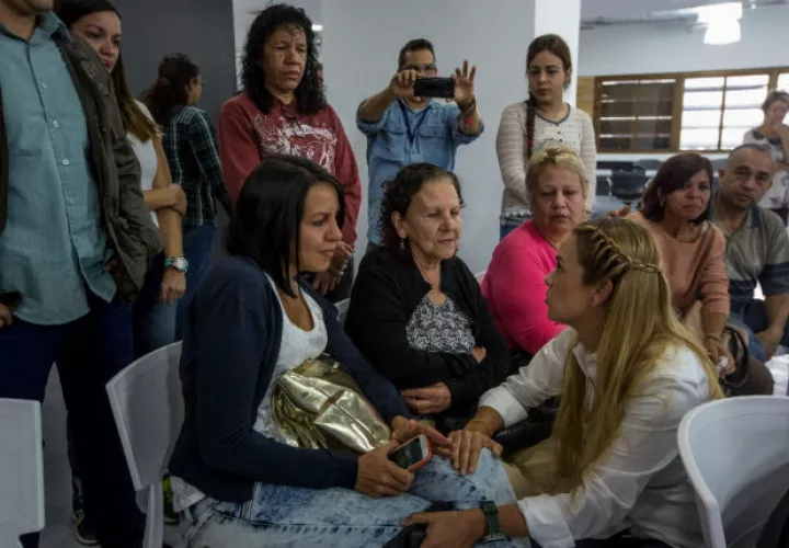 Lilian Tintori, esposa del opositor preso venezolano y líder del partido Voluntad Popular (VP), Leopoldo López, saluda a familiares del parlamentario Gilber Caro. FOTO/EFE