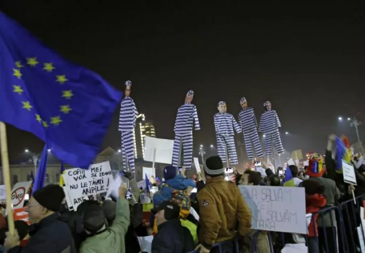 Manifestantes rumanos  portan muñecos con rostros de políticos presidiarios. EFE
