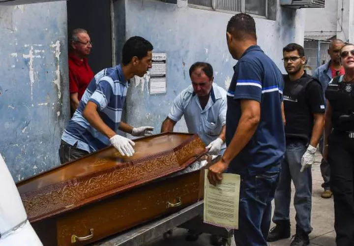 Un hombre trata de reconocer entre los muertos a un familiar. EFE