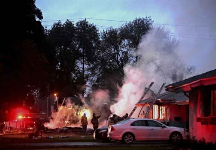 Los bomberos ingresaron a una de las viviendas incendiadas y sacaron a un pasajero inconsciente. FOTO/AP