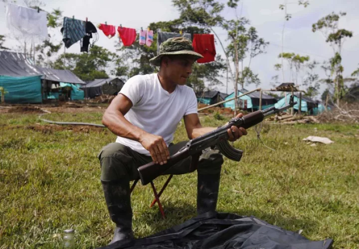 Uno de los guerrilleros limpia su arma, en una de las Zonas Veredales. /Foto AP