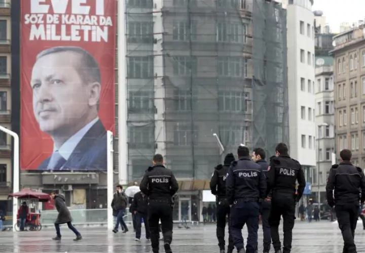 Policías caminan en Estambul,  frente a un póster con la imagen del presidente  Recep Tayyip Erdogan. /Foto EFE