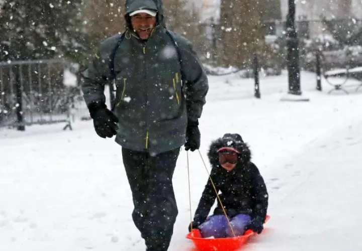 Un hombre con su hijo en trineo en un parque de Nueva York. /Foto EFE