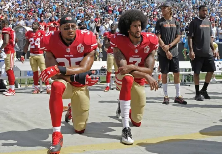 Kaepernick  (dcha.) no permanecía de pie cuando sonaba el himno.