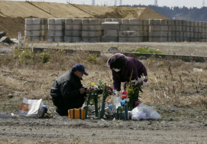 Un grupo de personas colocan flores y rezan en una de las localidades azotadas por el terremoto. FOTO/AP