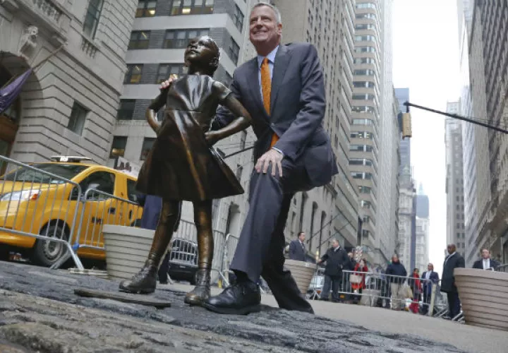 El alcalde de Nueva York, Bill de Blasio, posa con la polémica estatua de "Niña sin miedo". FOTO/AP